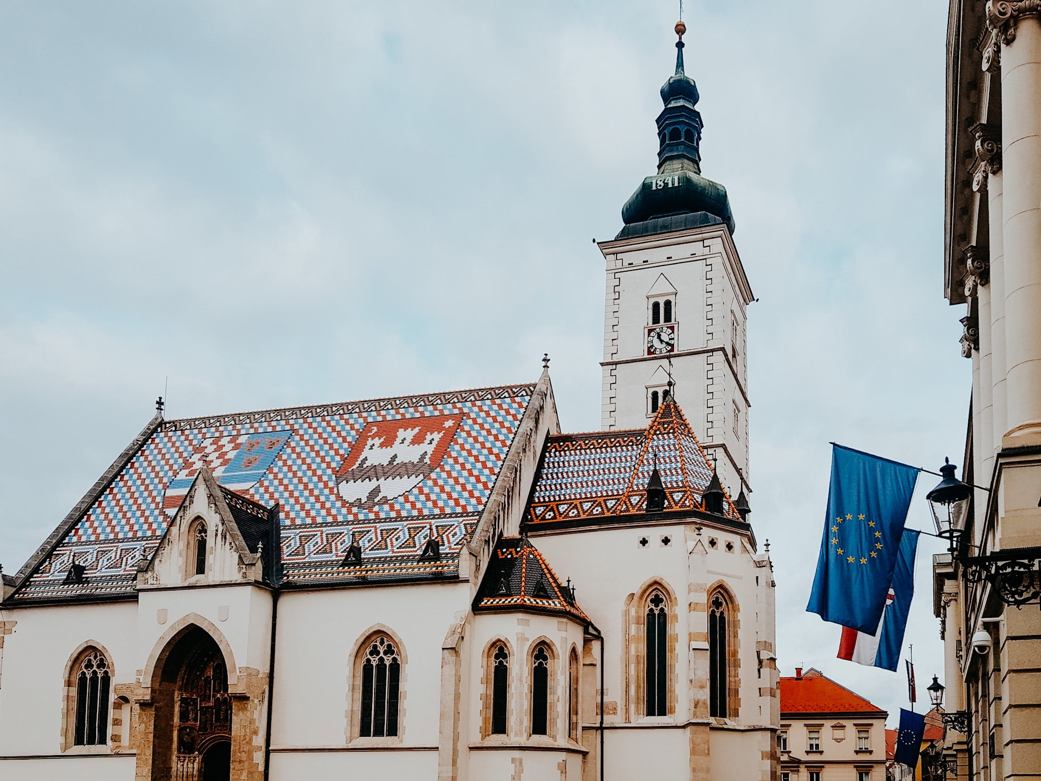 Kirche mit buntem Dach, Europaflaggen