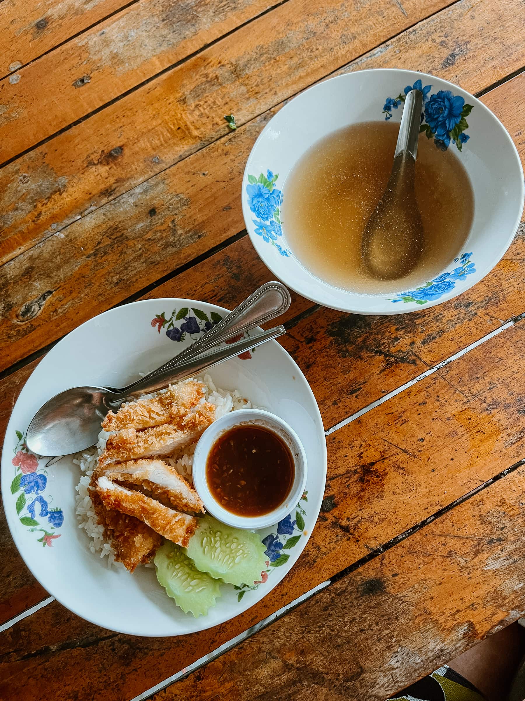 Thailändisches Street Food, ein Teller Reis mit knusprigem Hähnchen und eine Schüssel klare Brühe