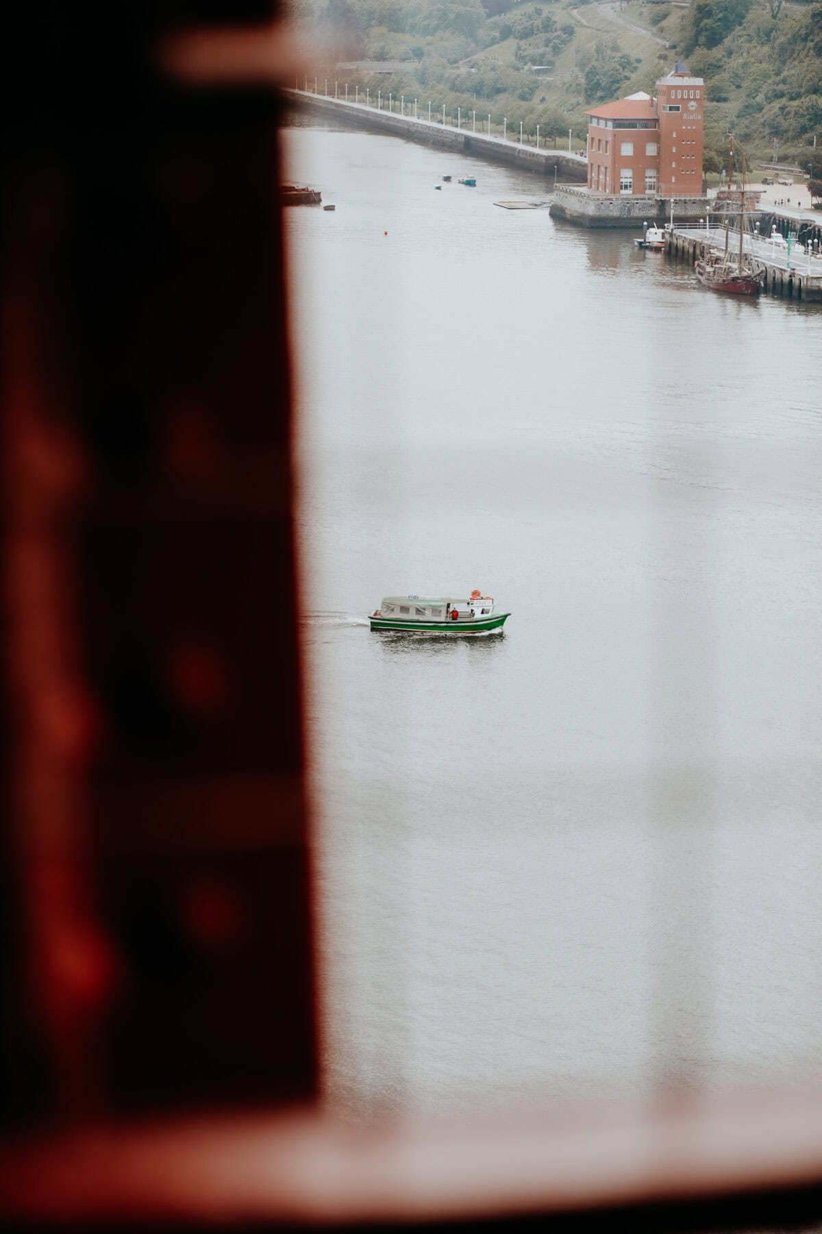 Green boat sailing on a calm river.