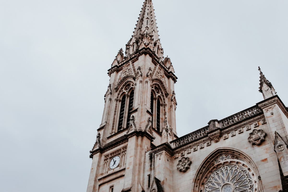 Gothic church tower with clock and rose window.