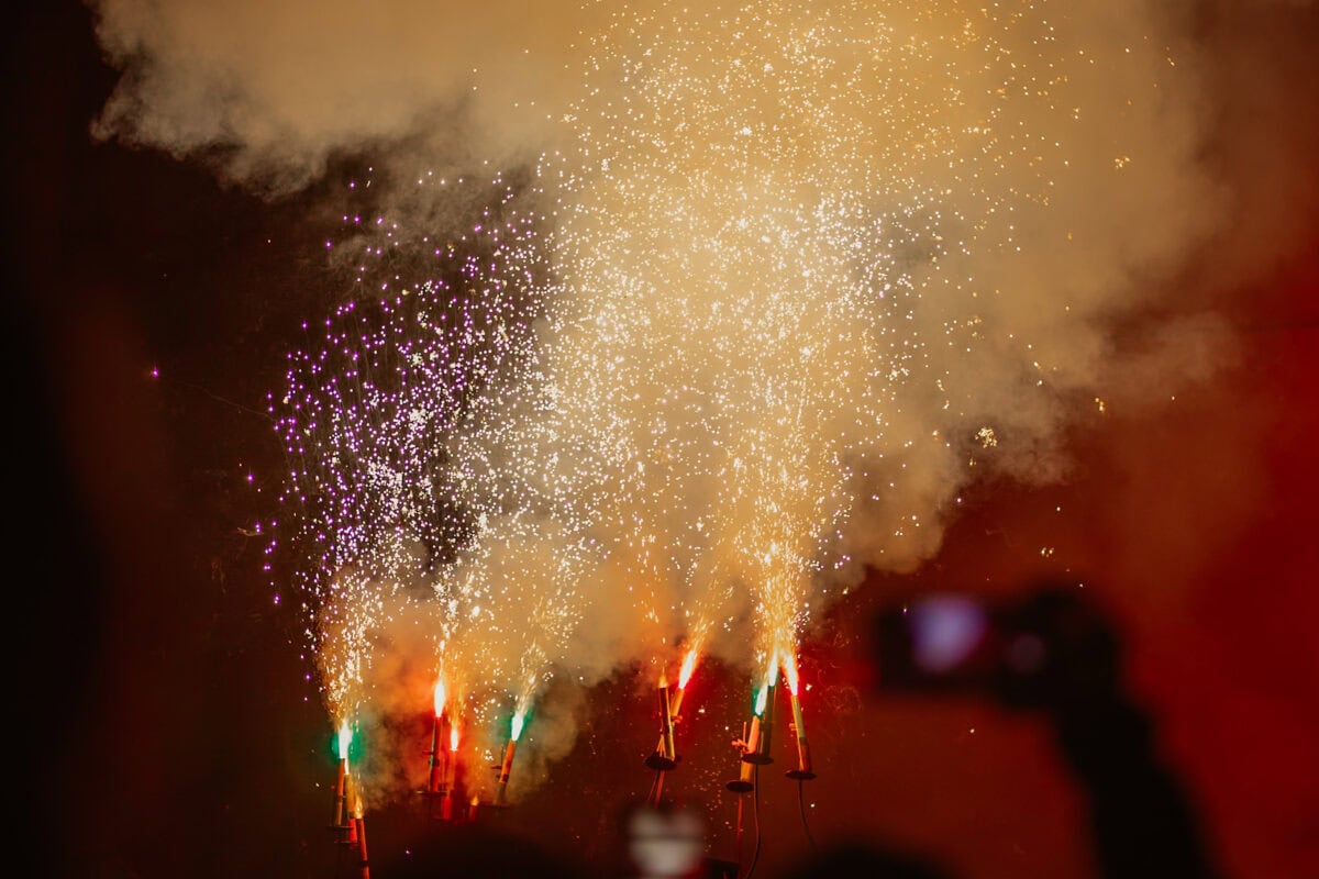 Colorful fireworks explode in the night sky.