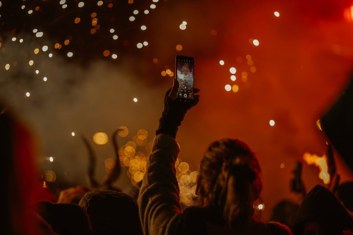 Person films fireworks with cell phone at night