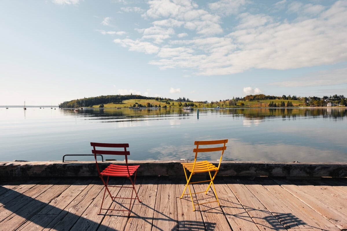 Two chairs on the lake shore, peaceful landscape