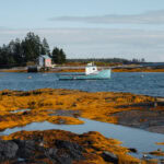 Boot vor einer Hütte am Seeufer