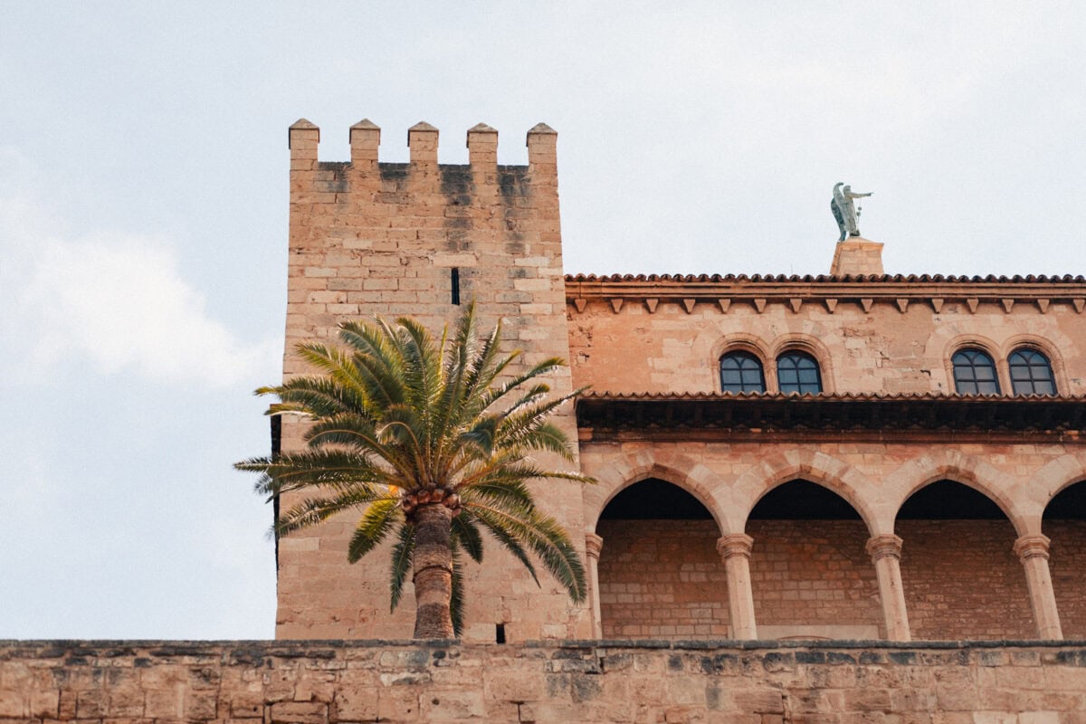 Medieval tower with palm tree in the foreground.
