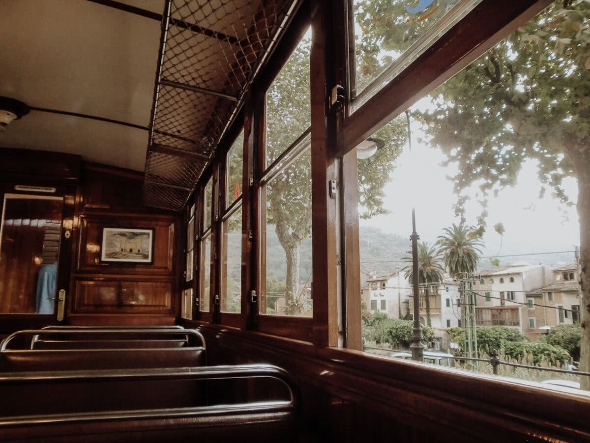 Old train compartment, view of trees and buildings.