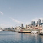 Ufer einer Großstadt mit Hochhäusern und Kreuzfahrtschiff