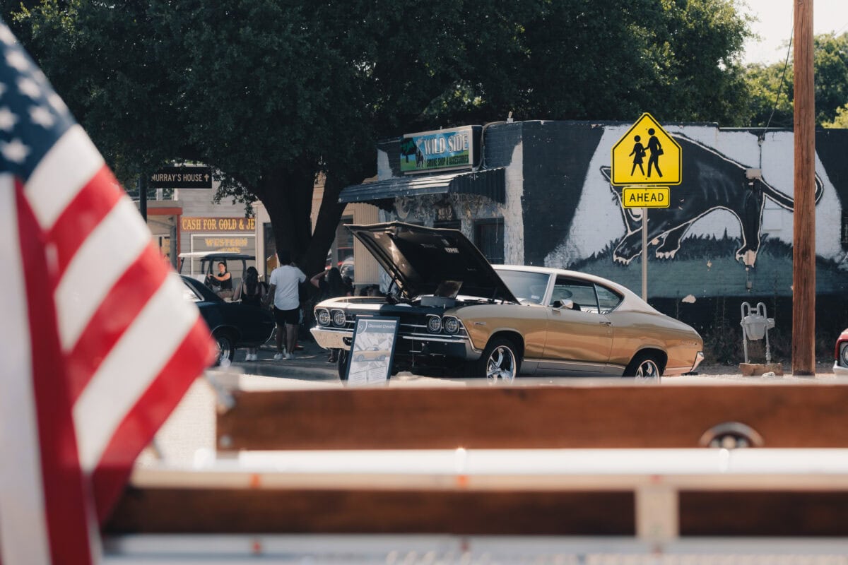 Classic car with hood open in the city.