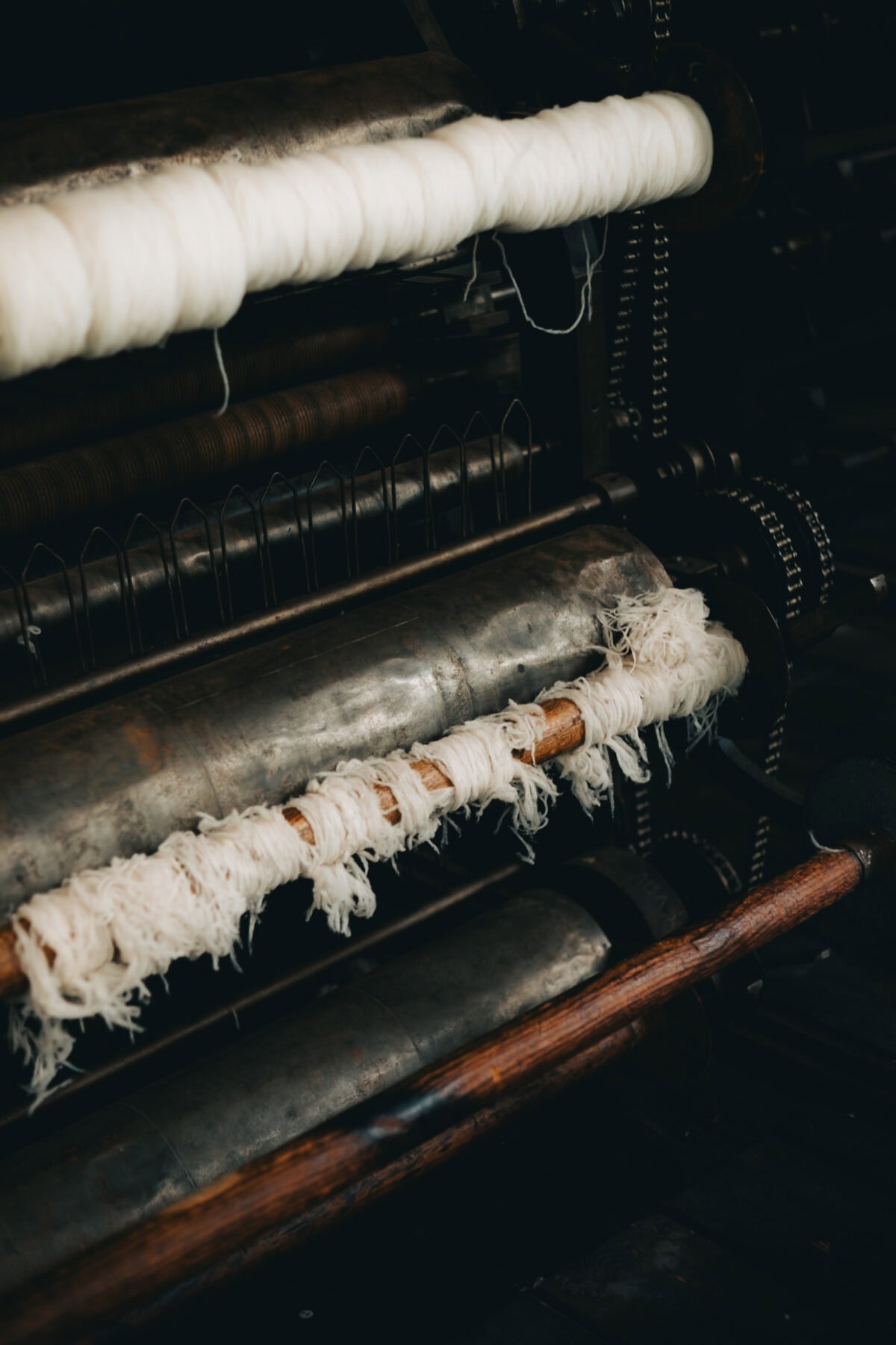 Alte Textilmaschine mit weißen Fäden.