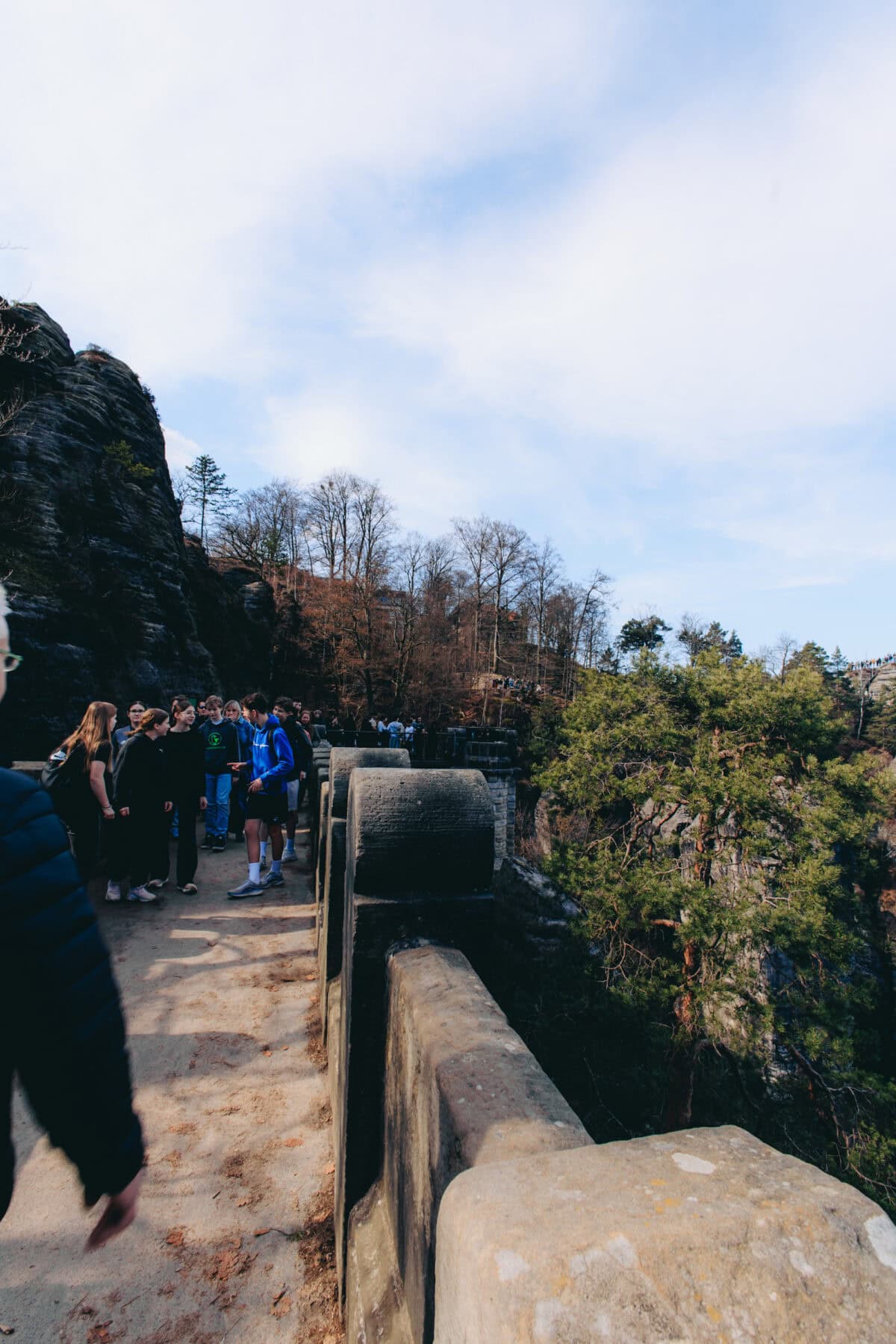 Menschen auf steinerner Brücke in felsiger Landschaft