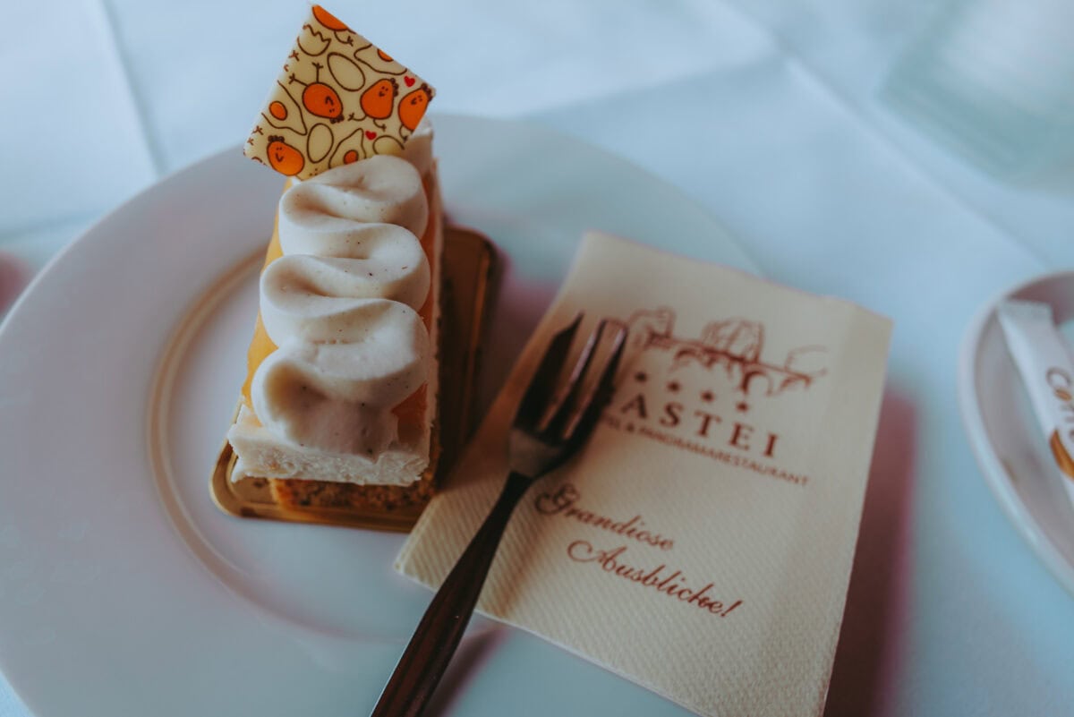 Stück Torte mit Cremehaube auf weißem Teller