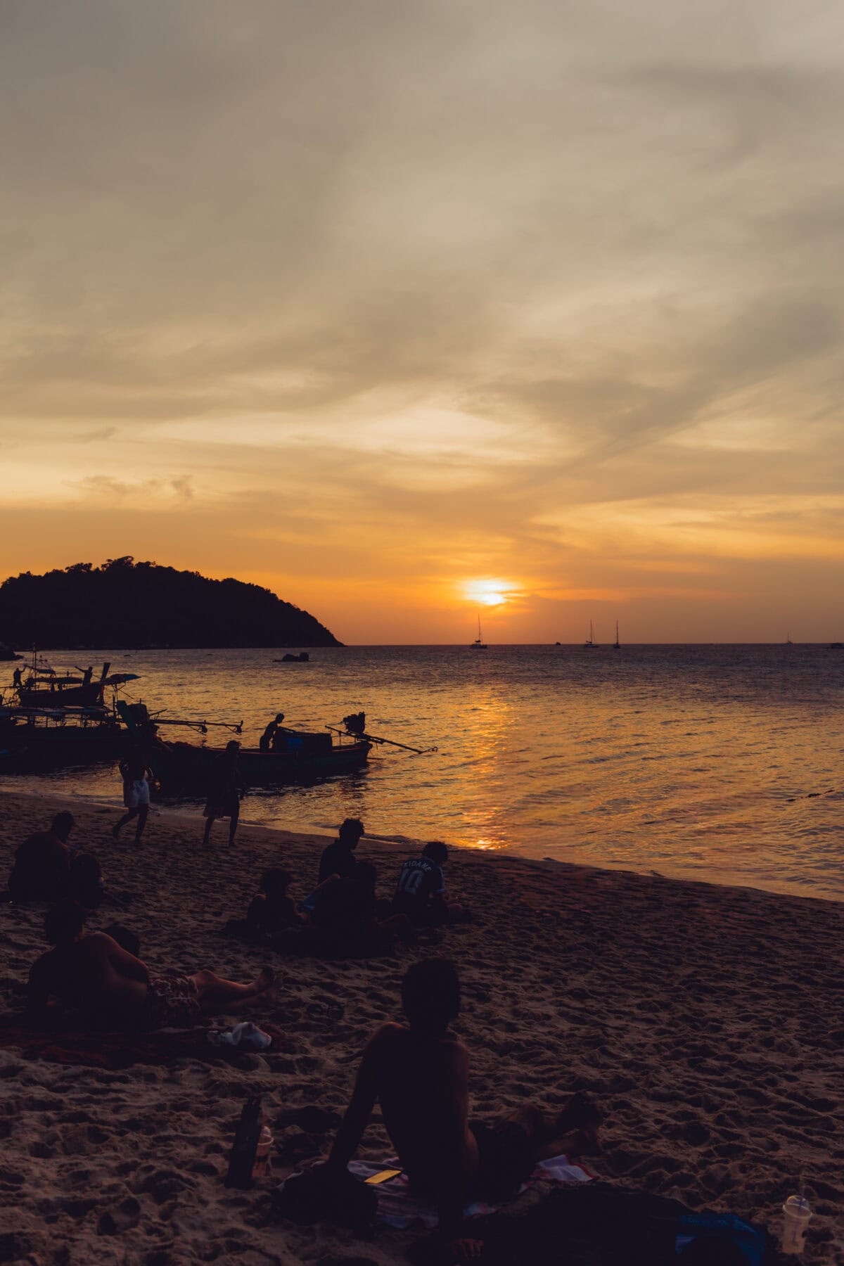 Sunset on the beach with boats and silhouettes