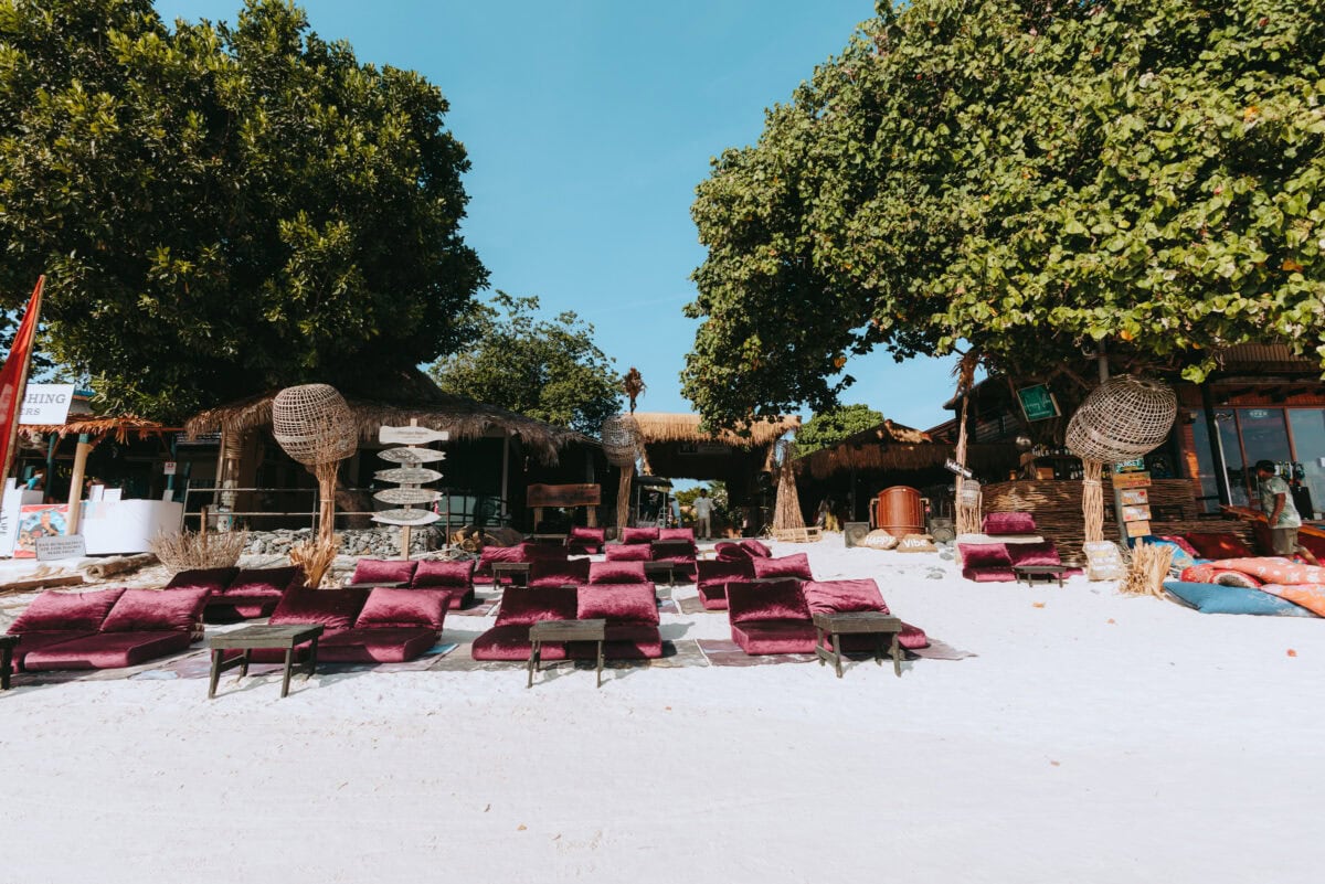 Beach bar with red cushions in the white sand