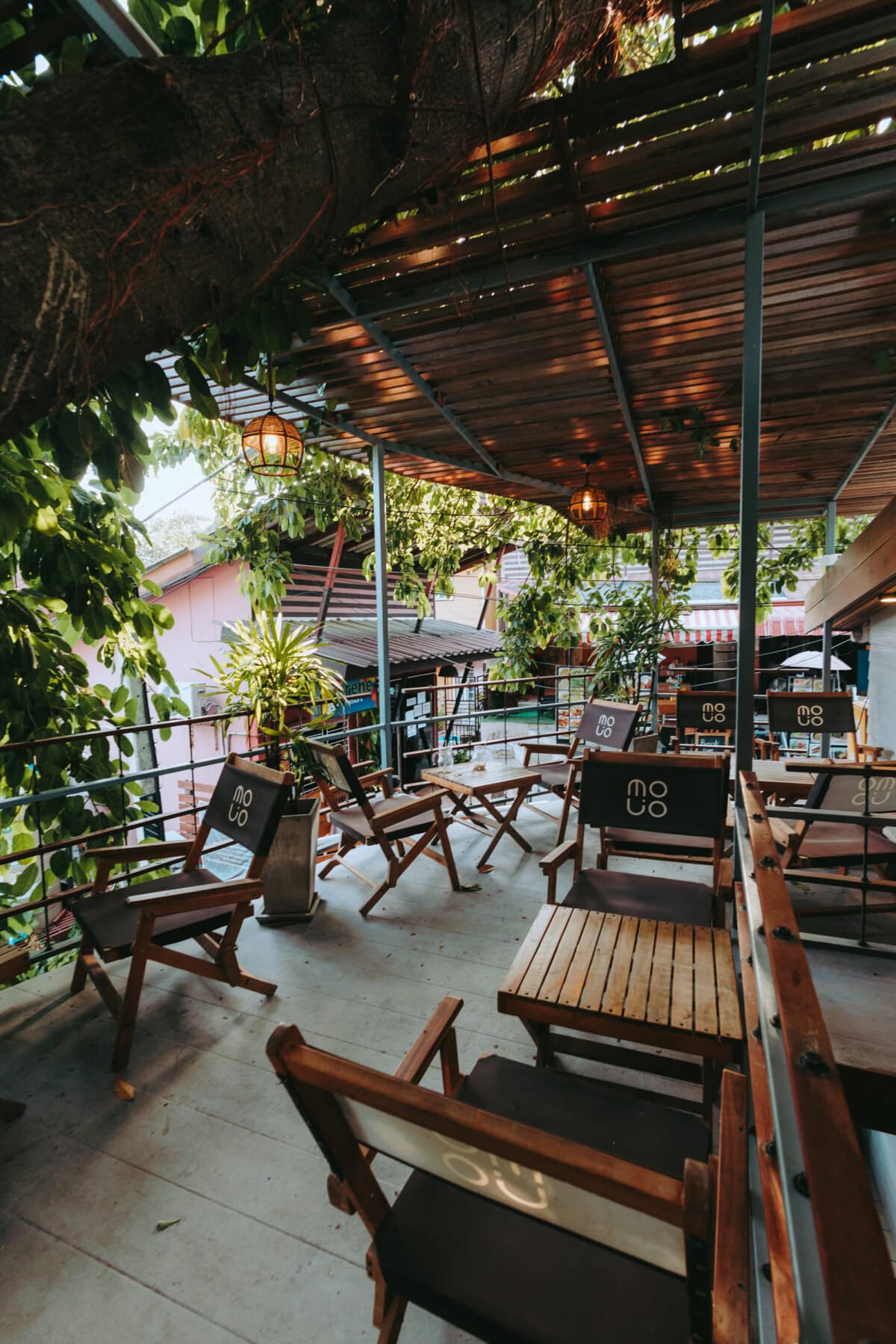 Cozy café terrace with wooden furniture and plants