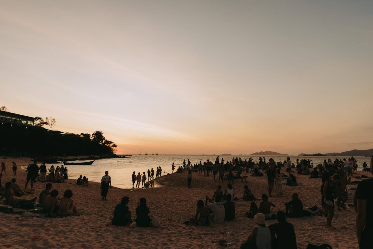 People on the beach at sunset by the sea