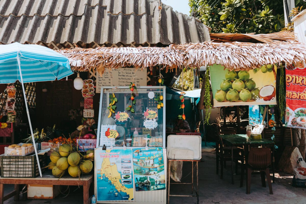 Thai street stall with coconuts and thatched roof