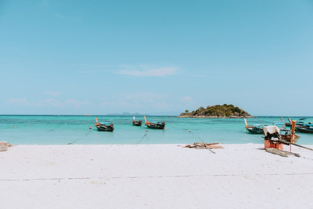 Longtail boats off a tropical island in the turquoise sea