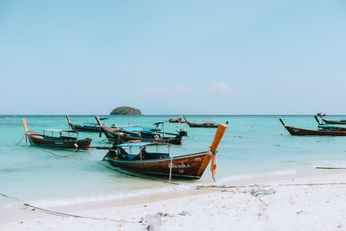 Longtail boats on a tropical beach with turquoise blue sea