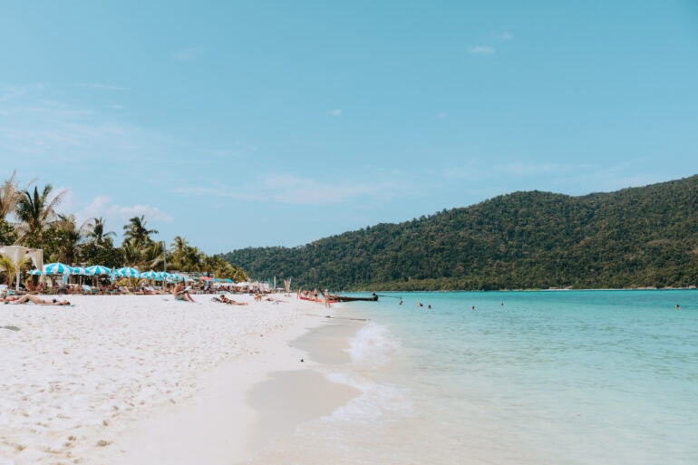 Tropischer Strand mit türkisfarbenem Meer und Palmen