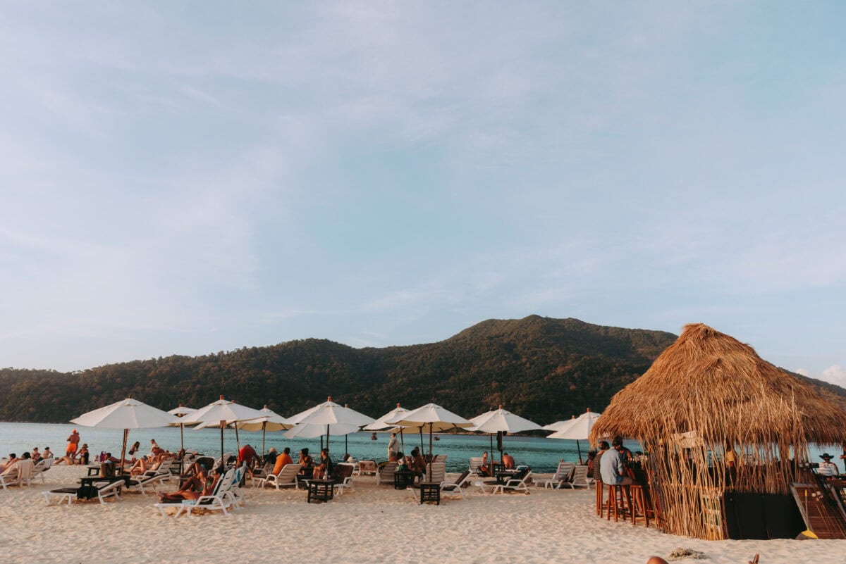 Lively sandy beach with parasols and beach bar