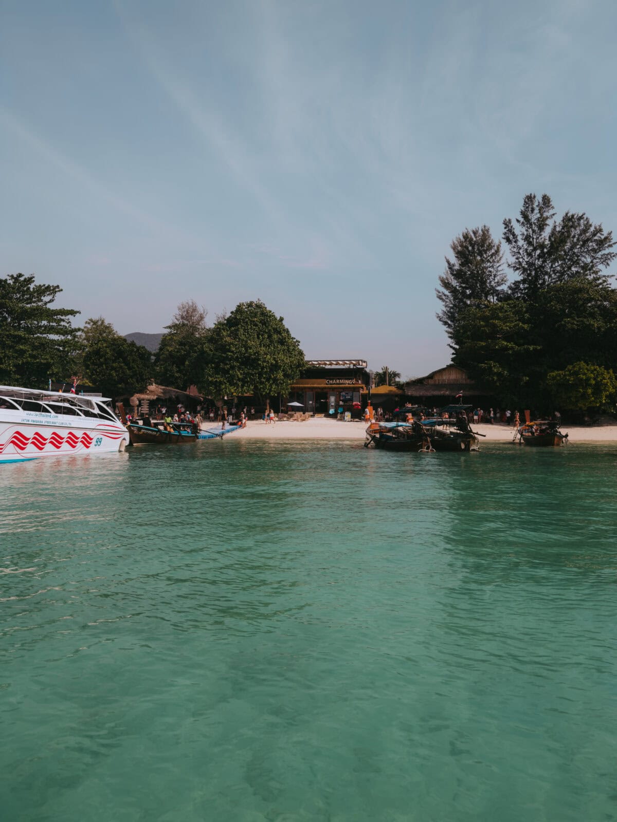 Boats in front of a tropical beach with turquoise water