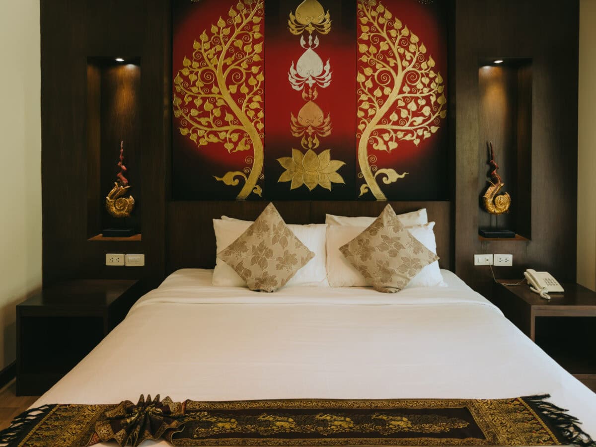 Elegant hotel bed with golden wall decoration
