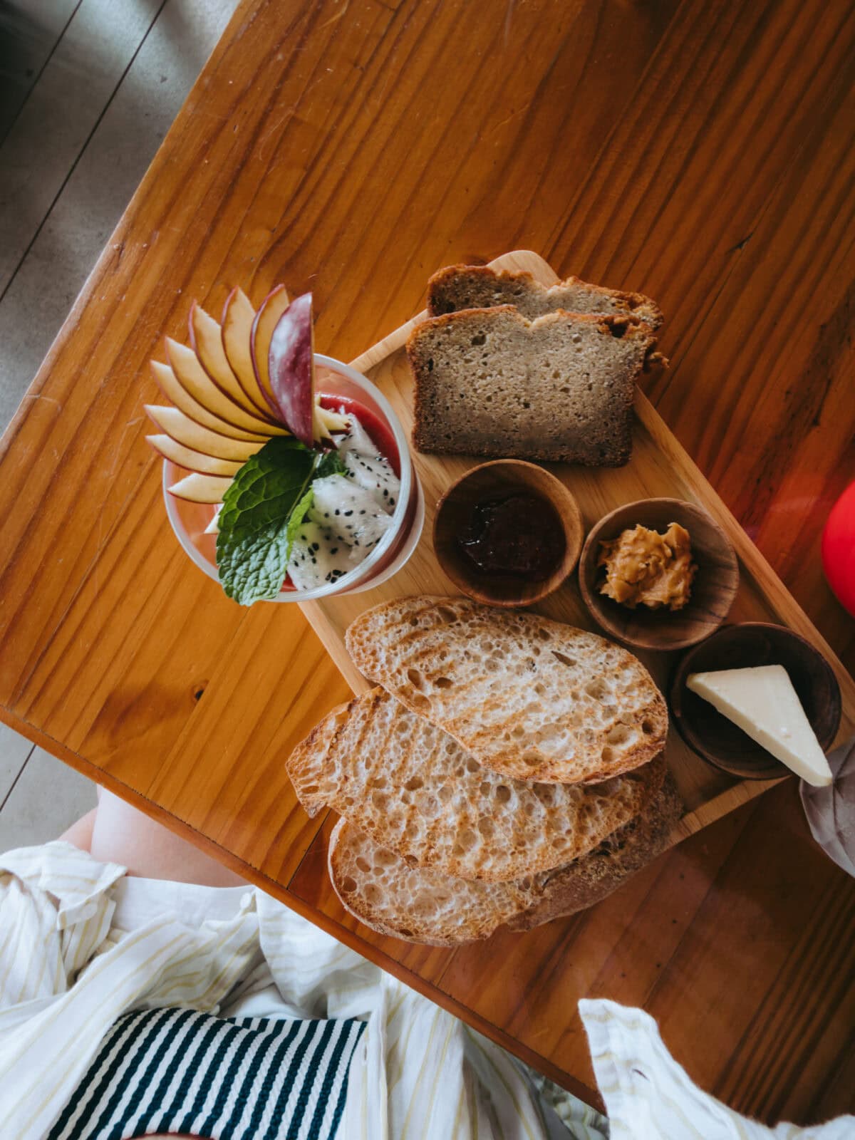 Breakfast with bread, fruit and spreads on a wooden table