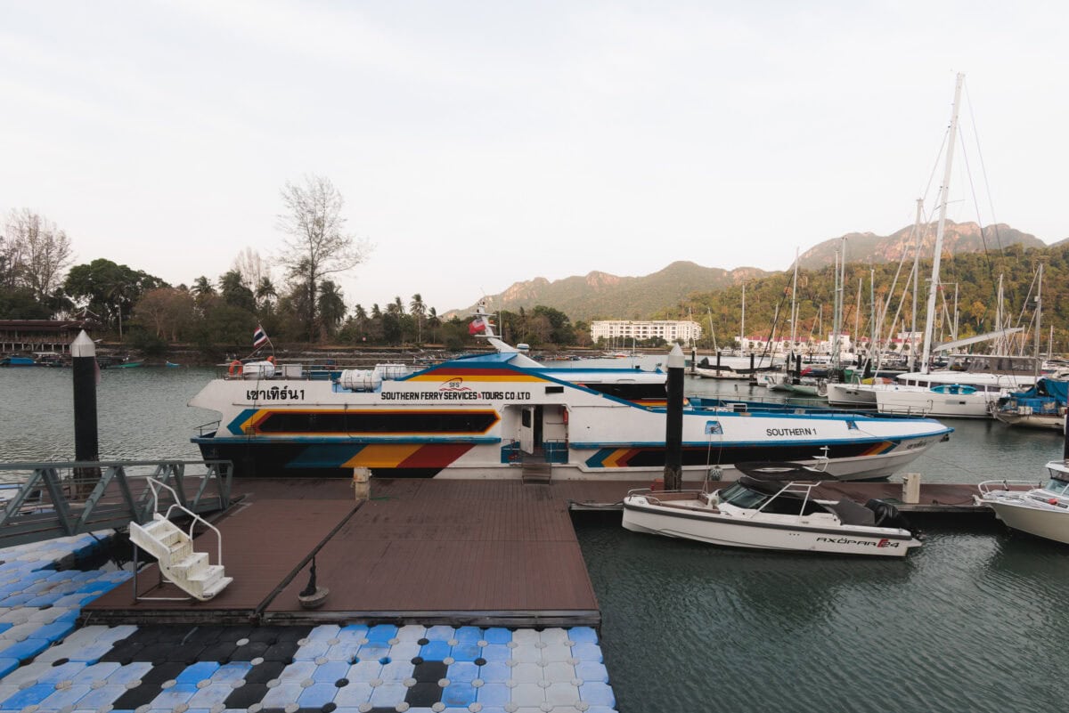 Ferry in the harbor in front of forested mountains